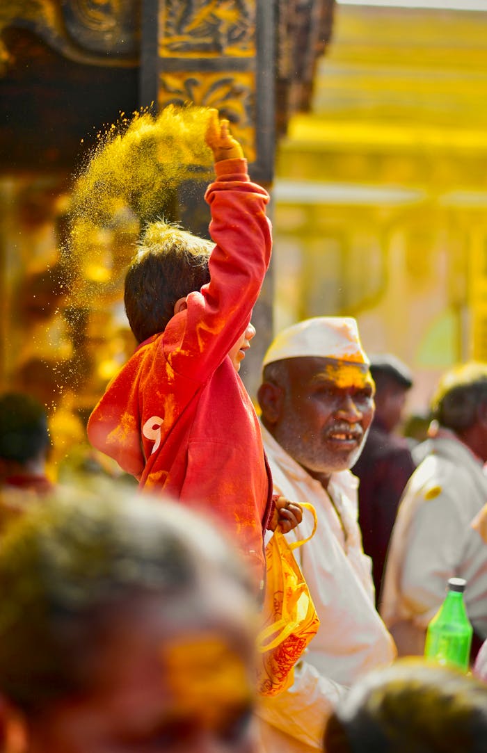 People celebrating with yellow powder during a festival in Jejuri, India.